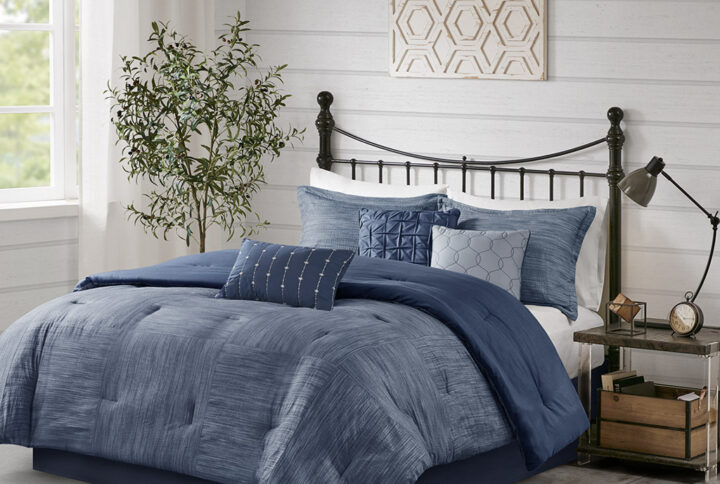 The Madison Park Walter 7 Piece Printed Seersucker Comforter Set offers a chic modern update to your bedroom. This navy comforter set features a pieced