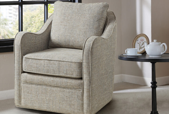 Bring simple comfort to your living room decor with the Madison Park Brianne Wide Seat Swivel Arm Chair. This swivel chair features a loose back and seat cushion that is fully upholstered for a chic transitional look. Double piping details along the frame accent the design