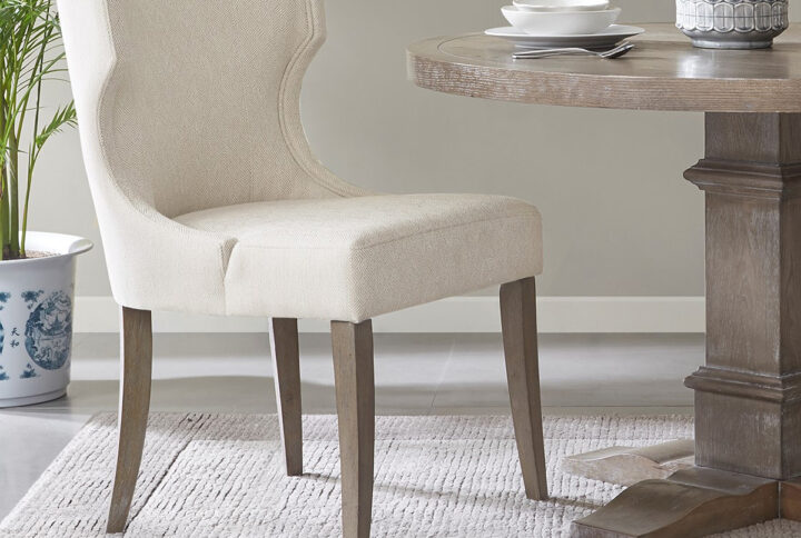 Define your dining room with the elegance of the Madison Park Carson dining chair. This upholstered dining chair features a wingback style back with piping details around the frame that create clean lines and curves