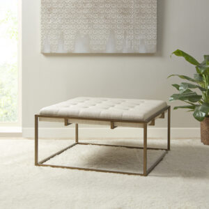 Elevate your living room décor with the elegance of the Madison Park Greenwich Ottoman/Coffee Table. This square ottoman is upholstered in a rich ivory fabric and features a tufted top that adds a sophisticated touch to the modern look. An antique bronze finish on the metal frame beautifully contrasts the upholstery