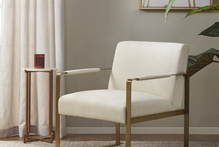 Elevate your living room decor with the luxurious style of the Martha Stewart Jayco Accent Chair from Perry Street collection. The seat and back are upholstered in a rich plush fabric that is complemented by the antique gold metal arms and legs