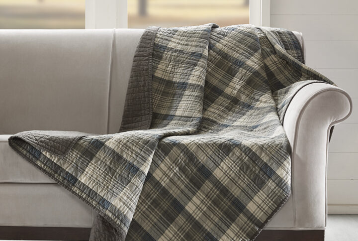 The Woolrich Tasha quilted throw features an all over brown and tan plaid and reverses to a solid brown color. Made from 100% cotton this lightweight throw is soft to the touch and can be used year round.