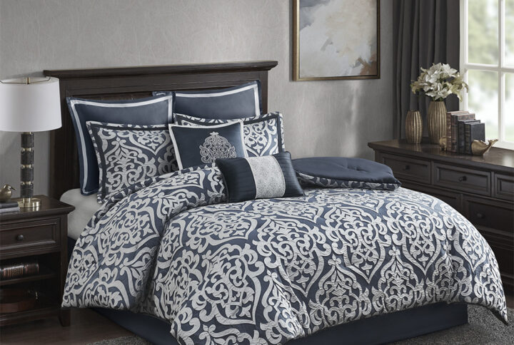 Add a touch of class to your bedroom with the Madison Park Odette 8 Piece Jacquard Comforter Set. The luxurious textured jacquard comforter and shams flaunt a gorgeous damask medallion design with silver striations on the satin ground that add dimension to the lavish look. A solid navy reverse and stunning Euro shams complement the top of the bed to complete the ensemble. Also included are two decorative pillows that feature embroidery and cording details