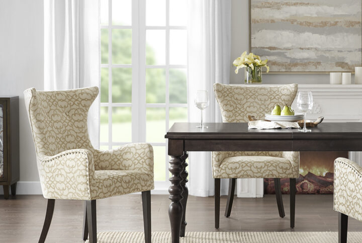 The Madison Park Angelica Dining Arm Chair 2 Piece Set brings a sophisticated update to your dining space. Each dining chair of this two piece set is upholstered in a rich tan fabric and features a bronze nail head trim for an added touch of elegance. A dark coffee wood finish on the straight legs creates a beautiful contrast with the upholstery. The round arms and high back flaunt elegant curves for a chic silhouette that gives your dining space a luxurious transitional touch. Leg assembly is required and tools are included for your convenience.