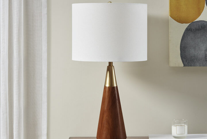 Simple architectural shapes in a pecan finish with gold accents will add style to your mid-century setting combined with the white linen shade.