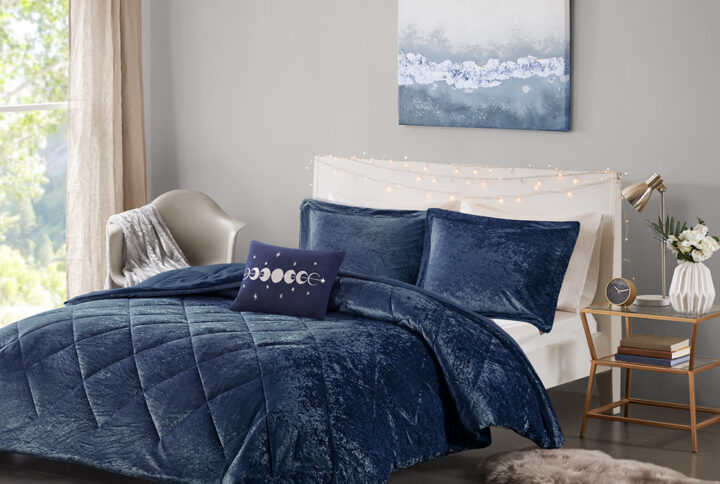 Create a lush and relaxing atmosphere in your bedroom with the Intelligent Design Felicia Velvet Comforter Set. The navy comforter is made from crushed velvet and features diamond quilting for a luxurious look. Matching crushed velvet sham(s) and an oblong decorative pillow complement the comforter to complete the modern style bedding set. Machine washable for easy care