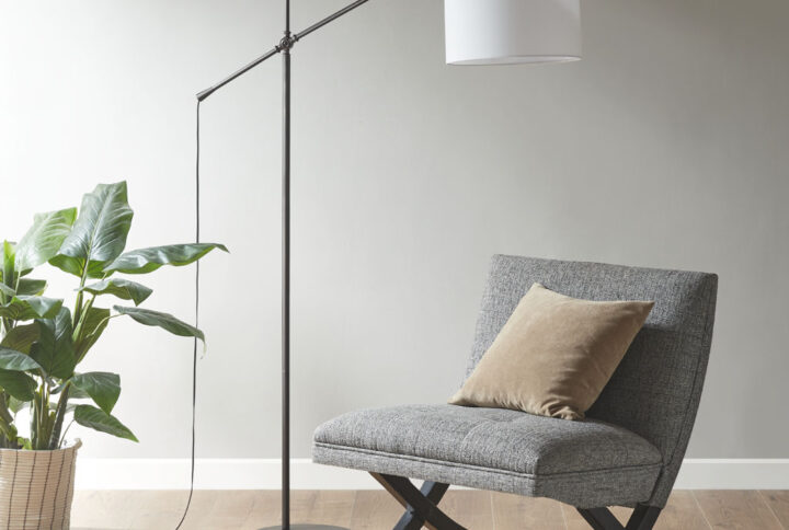 The INK+IVY Keller Adjustable Arched Floor Lamp with Drum Shade provides a sleek and simple addition to brighten up your living room. This slender metal floor lamp features a straight stand with an adjustable arm that raises and lowers the light to your desired height. The 14" linen drum shade softly filters the light to create a pleasant warm glow in your home. A black power cord completes the clean and casual design of this metal floor lamp. Use one Type A light bulb (not included).