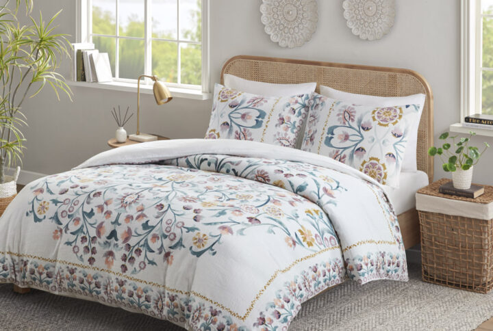 This shabby chic duvet cover set features a large floral print design in the center while blossoms line the edges of the comforter creating an enchanting border. Colors found in this bed set include various shades of teal