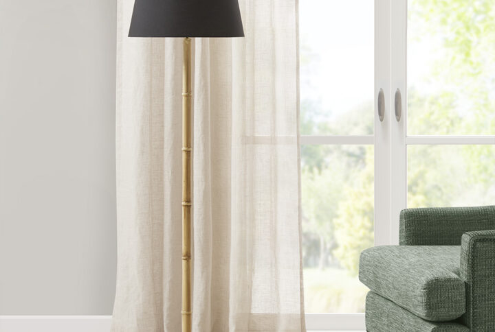 This 60"H Nassau Metal Bamboo Floor Lamp is inspired by Martha Steward's shingle-style beach home and is part of Martha Stewart's Lily Pond collection. The lamp features a bamboo design with a contrasting black base and tapered drum shade. It's made from durable metal and has an on/off switch inline. The 72-inch clear colored cord plugs into an outlet