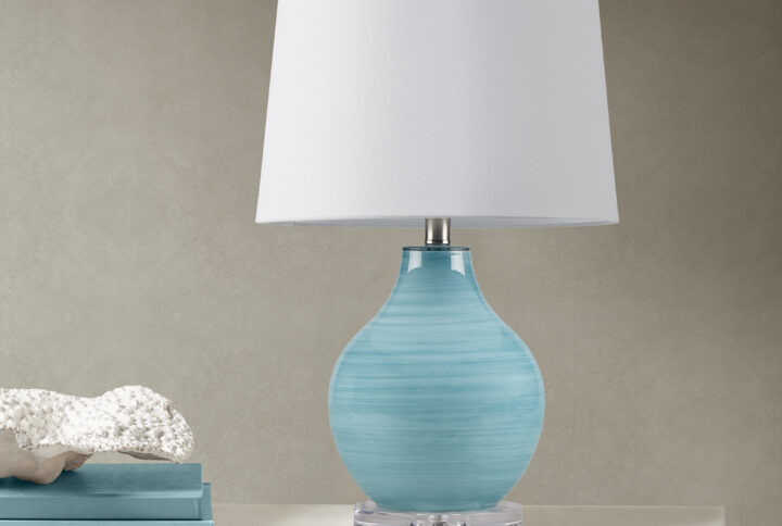 Transform your space with the Maelle Glass Table Lamp by 510 Design – where artistry meets functionality. Crafted from stunning blue aqua swirl blown glass