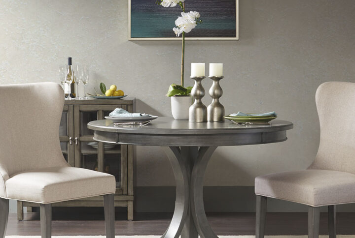 Gather round the Madison Park Signature Helena Round Dining Table. Featuring a grey wood finish with distressed edge detail