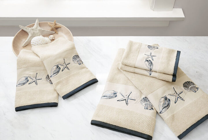 Complete the beach look of your bathroom our Madison Park Bayside Embroidered Cotton Jacquard 6 Piece Towel Set. This solid natural textured jacquard towel set features a stylish hem highlighted by an embroidered coastal motif of blue sea shells and starfish