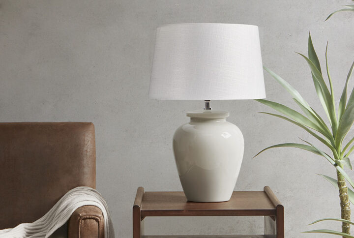 The INK+IVY Anzio Ceramic Table Lamp offers a simple and traditional addition to brighten your home decor. This table lamp features a round ceramic base with a rich cream finish to create a charming neutral look. The white lamp shade showcases a drum shape that complements the design of the base and softly filters the light