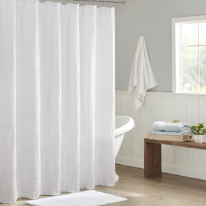 Give your bathroom a spa-like allure with the Madison Park Arlo Super Waffle Textured Solid Shower Curtain. This solid White shower curtain features a heavy waffle weave base fabric that creates a rich texture for a simple and stylish update. The medium weight fabric allows a natural and rich drapability