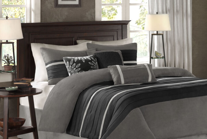 The Madison Park Palmer 7 Piece Comforter Set offers a classic and refined update to your bedroom decor. This transitional style comforter features a pieced microsuede design in rich contrasting black and grey colors to create an incredibly soft look and feel. The 2 matching shams also flaunt a pieced construction to coordinate with the faux suede comforter. A solid grey bed skirt and 3 decorative pillows with a mix of embroidered designs add the perfect finishing touches to complete this lush traditionally-inspired comforter. Machine washable for easy care