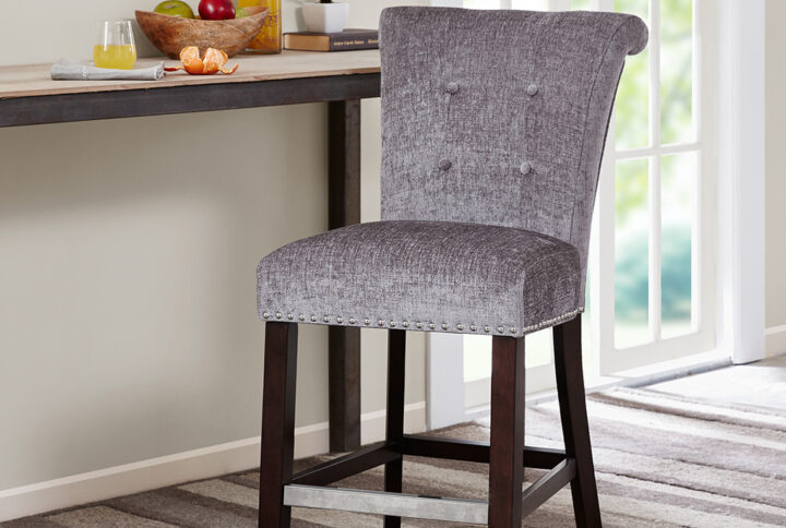 Elegant silver nail heads add an extra touch of dignified style to this roll back button tufted counter stool. Assembly required.