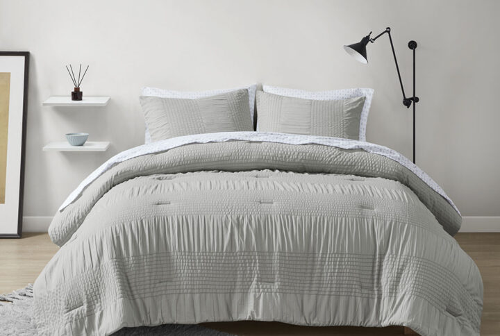 Refresh your bedroom style with the modern allure of the Madison Park Essentials Nimbus 7 Piece Comforter Bedding and Sheet Set. The comforter features a motif of alternating solid and textured stripes to create a casual and contemporary look