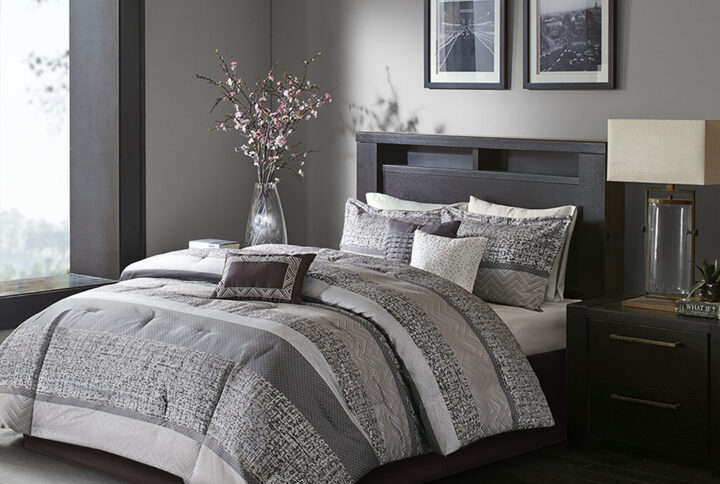 Give your bedroom a new luxurious look with the Madison Park Rhapsody 7 Piece Jacquard Comforter Set. This jacquard comforter features a grey and taupe stripe design of several different motifs on the face with a solid grey reverse