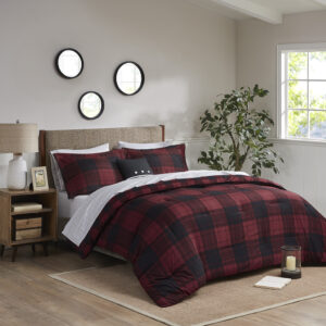 The Madison Park Essentials Everest Reversible Comforter Set with Bed Sheets brings a cozy cabin allure to your bedroom decor. A red and black buffalo check print adorns the front of the ultra-soft microfiber comforter