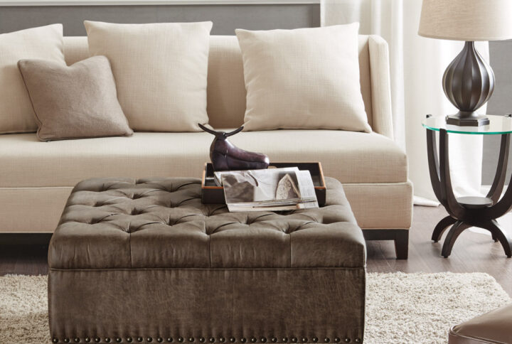 Complete your living space with the Madison Park Lindsey Tufted Square Cocktail Ottoman. This large square ottoman is upholstered fabric and features a button tufted top with piping details to create a chic traditional look. A nail head trim on bottom of the frame adds an elegant touch to the design