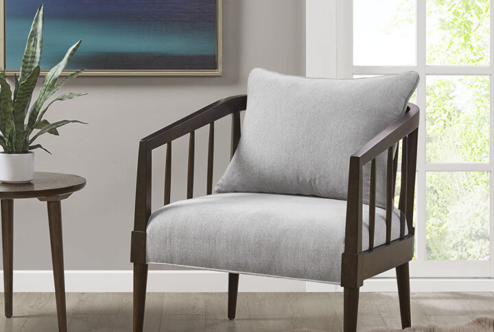 Bring simple comfort and a casual style to your living room with this modern armchair. The wood frame and flared arms feature an open spindle design in a rich