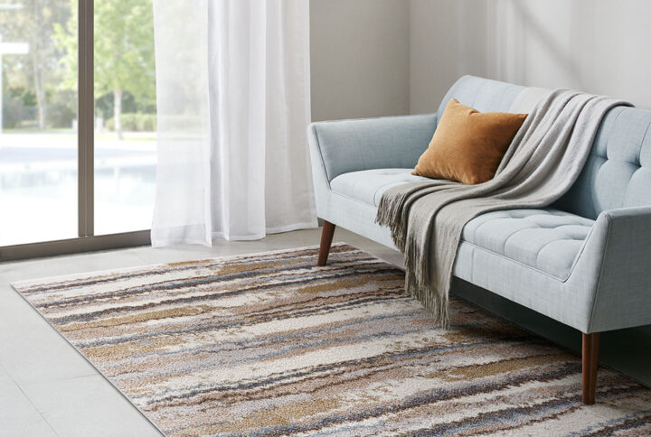 Add a modern textural touch to your living space with the Madison Park Riley Cozy Shag Watercolor Area Rug. This plush area rug flaunts cool shades of blue and tan in a watercolor design that creates a rich contrast to easily complement your decor. The super soft