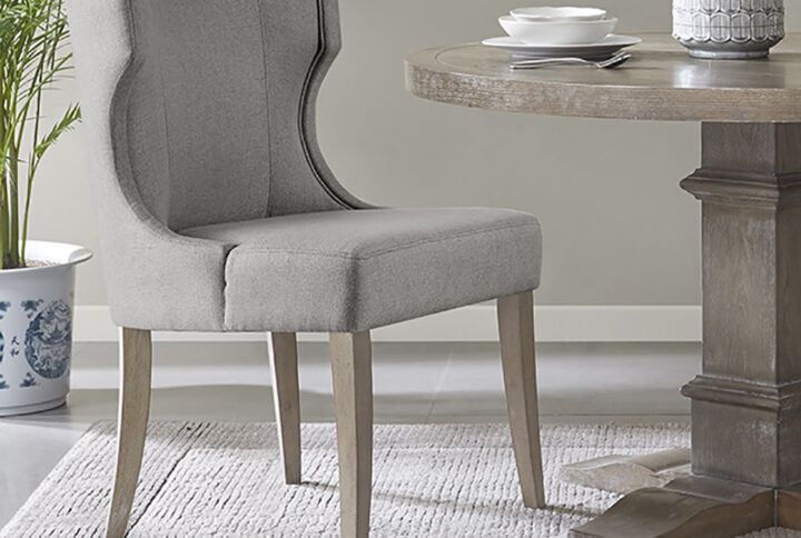 Define your dining room with the elegance of the Madison Park Carson dining chair. This upholstered dining chair features a wingback style back with piping details around the frame that create clean lines and curves