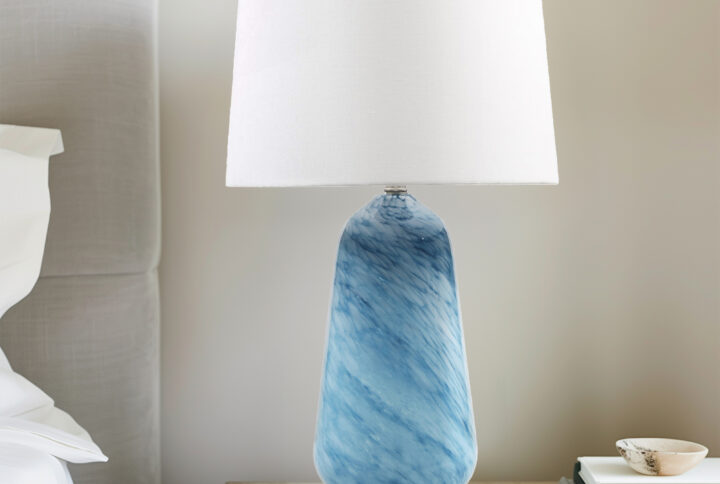 Transform your space with the Aquaviva table lamp from INK+IVY—where artistry meets functionality. Crafted from stunning blue confetti glass