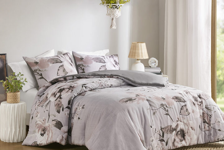 This shabby chic comforter set features a large scale engineered floral print design in shades of mauve