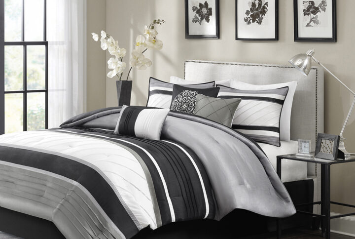 The Madison Park Blaire 7 Piece Comforter Set offers a rich traditional update to your bedroom decor. The comforter and matching shams feature pieced lustrous silk fabric and pintucking details