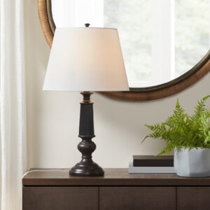 traditional base design features a sculptural and faceted pedestal style in a high-gloss black finish and is paired with a tapered drum shaped light-colored shade. The lamp also includes an on/off rotary switch on socket and comes with 1 Type A