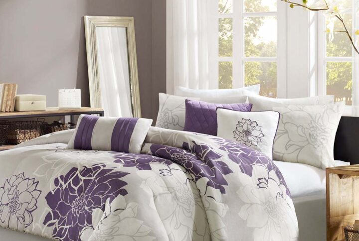 The Madison Park Lola Comforter Set transforms your bedroom into a beautiful and graceful space. A gorgeous floral print in a soft white and purple hue pops against the solid taupe grey ground cotton sateen comforter and shams (1 for Twin/Twin XL Sizes) for a stunning transitional look. Three decorative pillows with embroidered details and fabric manipulation add texture and dimension to the bed