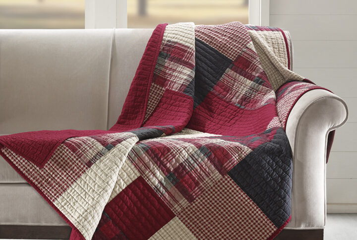 The Woolrich Sunset quilted throw features a a mix and match of plaids and solids and reverses to a solid red color. Made from 100% cotton this lightweight throw is soft to the touch and can be used year round.