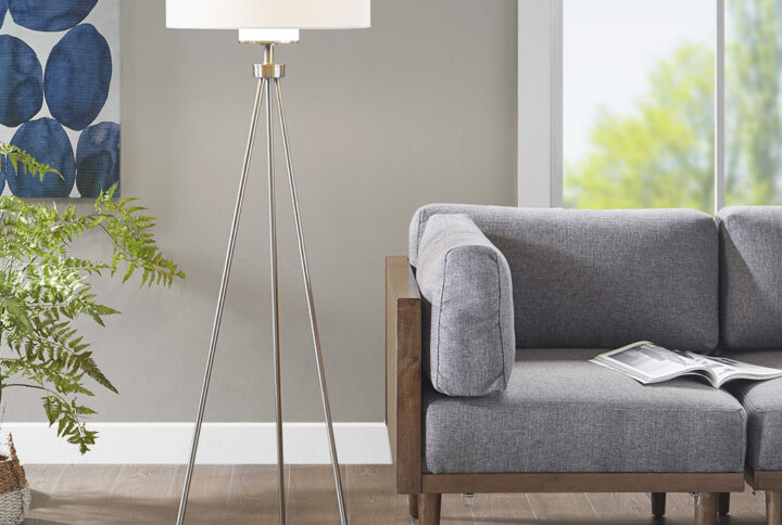 Add a modern flair to your space with the INK+IVY Pacific Metal Tripod Floor Lamp with Glass Shade. This one-of-a-kind floor lamp sports a tripod stand with a silver metal finish that creates an artistic balance of positive and negative space. The drum-shaped lamp shade comes in a grey hue that helps soften the look. Perfect in your living room or home office