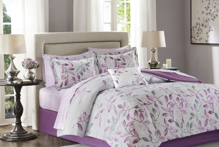 The Madison Park Essentials Lafael Complete Comforter and Cotton Sheet Set offers a charming update for your bedroom. The grey comforter showcases purple and dark grey leaves with a solid purple reverse