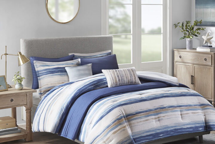 Create a relaxing and tranquil atmosphere in your bedroom with Madison Park’s Marina 8 Piece Printed Seersucker Comforter and Quilt Set Collection. The textured seersucker comforter features a watercolor stripe print in blue