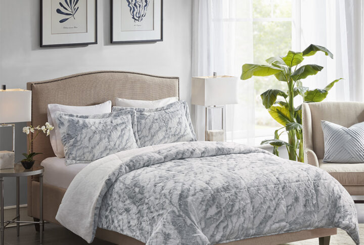 Feel the warmth and comfort when you slide into bed with the Madison Park Lana Long Faux Fur Comforter Set. This long faux fur comforter and shams feature a grey and blue marble pattern on a white base