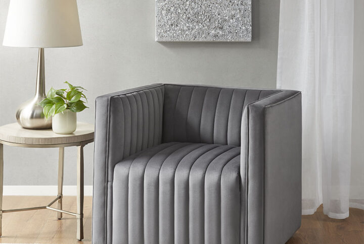 The Madison Park Sikora Channel Tufted Swivel Armchair offers a luxurious and modern update to your home décor. This swivel accent chair is upholstered in a gray polyester velvet fabric to provide a soft