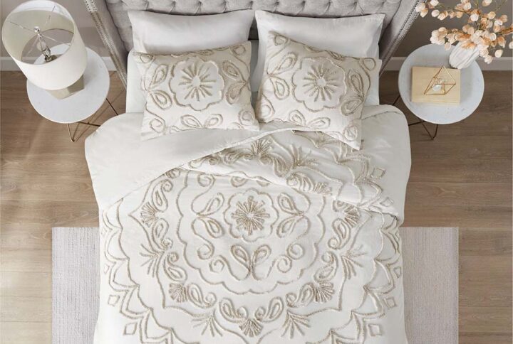 The Madison Park Violette 3 Piece Tufted Cotton Duvet Cover Set offers an elegant and charming update to brighten your bedroom décor. An ivory and taupe medallion design