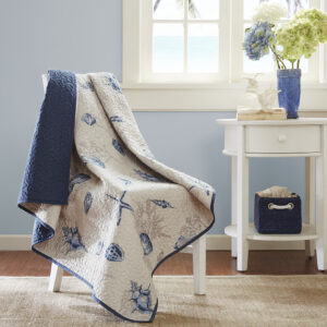 The Madison Park Bayside quilted throw creates a casual coastal look.  The throw features assorted seashells accentuated with light and dark blue coloring on an ivory background. In a deep taupe color