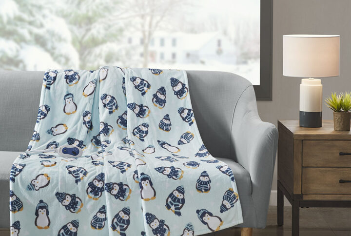 Wrap yourself up in the adorable comfort of the Beautyrest Oversized Plush Heated Throw. A cute penguin printed motif is displayed on the aqua ultra-soft plush base fabric