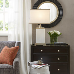 Bring a touch of elegance to any room in your home with the Hampton Hill Colette Ceramic Table Lamp. This rectangular table lamp features an ivory ceramic stand with an antique silver metal base and top to create a sophisticated transitional look. The off-white cotton shade softly filters the light into your room and is accented with a grey trim to complement the design. No assembly required.