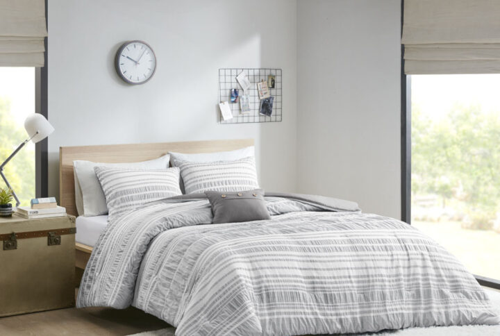 The Intelligent Design Lumi Striped Comforter Set offers a chic casual comfort to your bedroom. This comforter features a modern grey stripe pattern that has a ruched and yarn-dyed look to create dimension