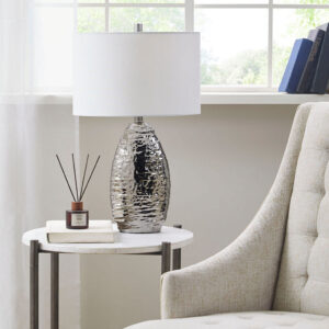 The Hampton Hill Livy Oval Textured Ceramic Table Lamp offers a bright and elegant update to your home decor. Featuring a curved ceramic base