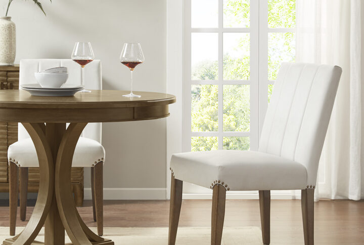 Refine the look of your dining room with the Madison Park Audrey Dining Chair Set of 2. Each accent dining chair is upholstered in a rich cream fabric and features vertical channel stitching on the back