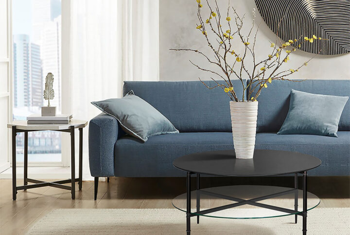 The Martha Stewart Caroline Round Coffee Table with Interchangeable Wood and Glass Top offers a bold and eye-catching centerpiece for your living room. This round coffee table features a clear tempered glass table top and lower wood shelf