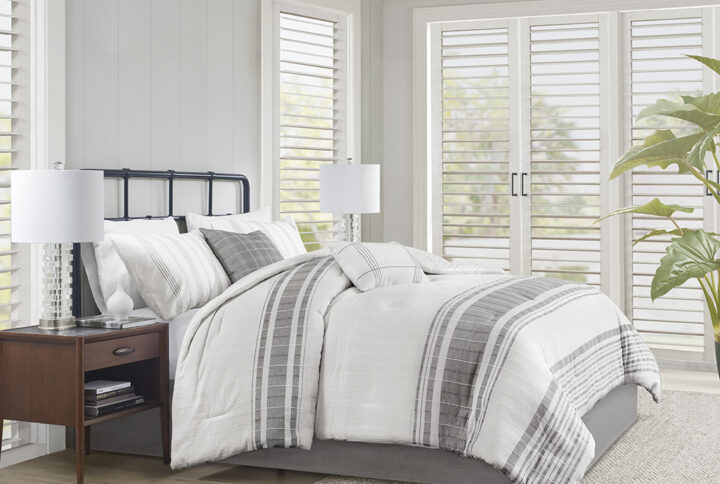 Introduce an upscale cottage charm to your bedroom with the Harbor House Morgan 6 Piece Cotton Comforter Set. This 100% cotton jacquard comforter features textured vertical woven stripes with contrasting horizontal blue stripes on ivory ground