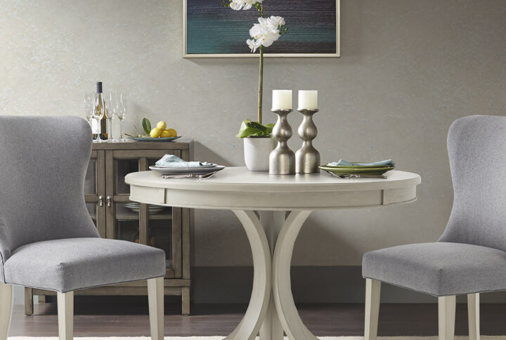 Make a statement in your dining room with the Madison Park Signature Helena Round Dining Table. This table features a wood veneer table top and solid wood pedestal legs. To accentuate the curves of the table it is coated in an antique cream finish. The round table seats four people comfortably. Leg assembly required