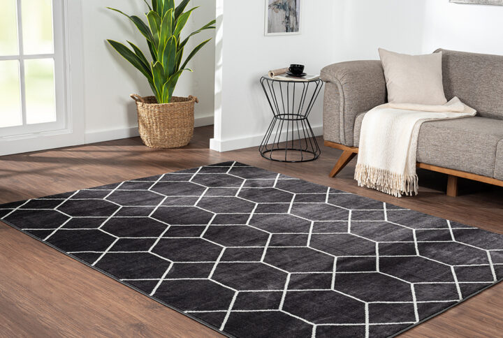 Elevate your home with the modern flair of Madison Park’s Averie Trellis Geometric Black and Cream Woven Area Rug. Made in Turkey