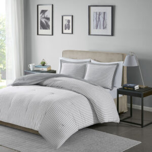 The Madison Park Essentials Hayden Reversible Down Alternative Comforter Mini Set gives your bedroom a fresh casual update. Sporting a grey striped pattern